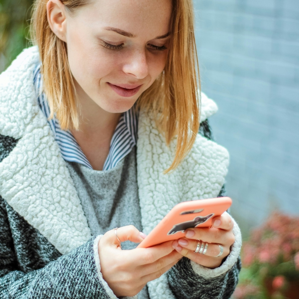 Femme consultant son smartphone en extérieur avec sourire